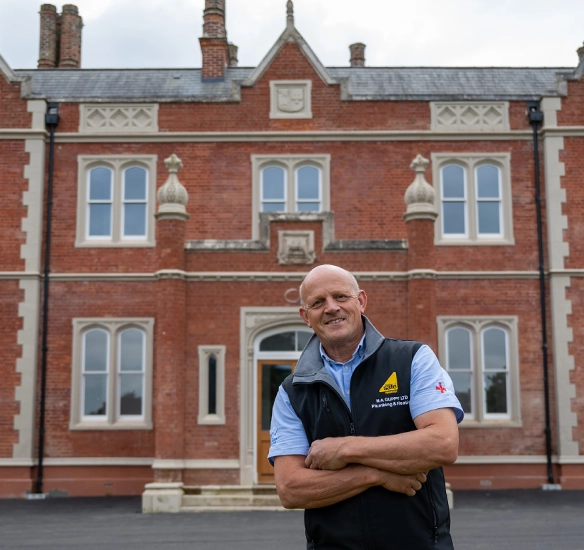 installer standing outside large house